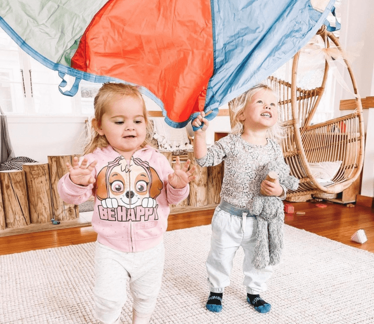 Children playing with parachute at childcare centre