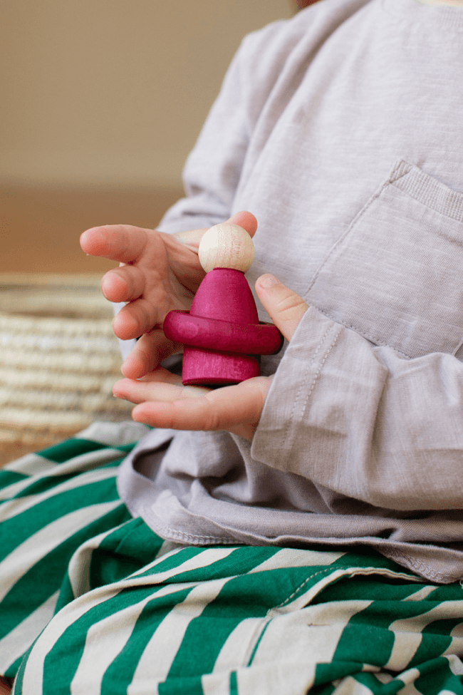 child playing with small wooden toy