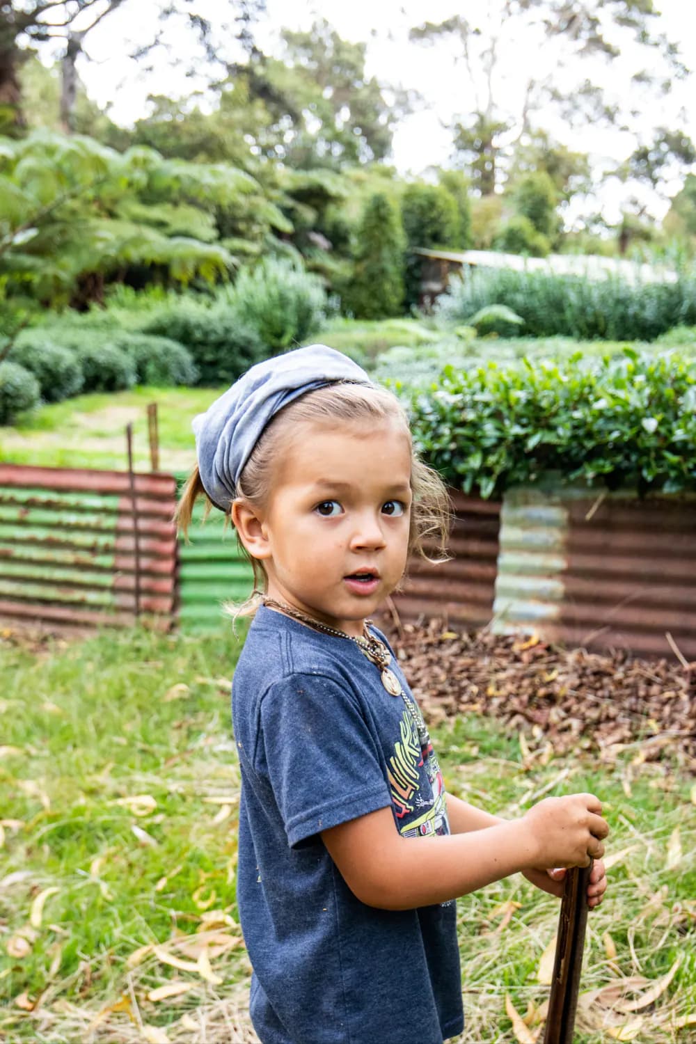 Young boy holding spade in yard