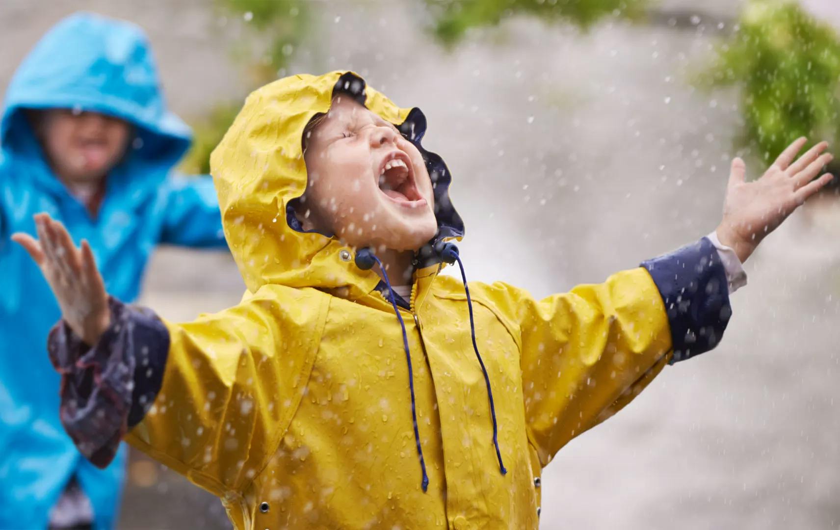 Child playing in a yellow rain jacket