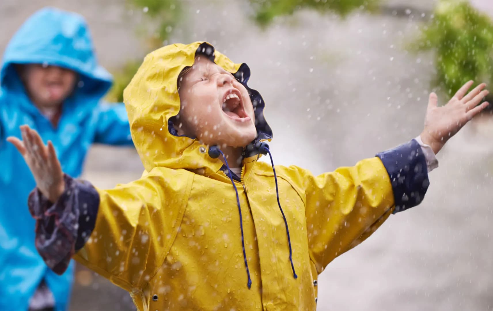 Child playing in a yellow rain jacket