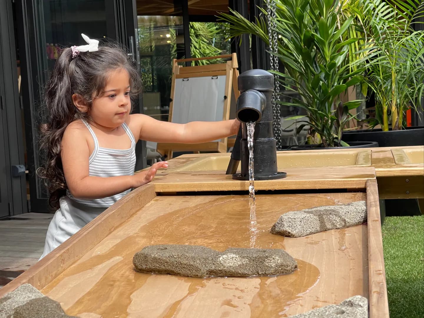 Child playing with water at Kakapo Creek Childrens garden